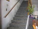 Stairway on North side living room. Note thermostat placement